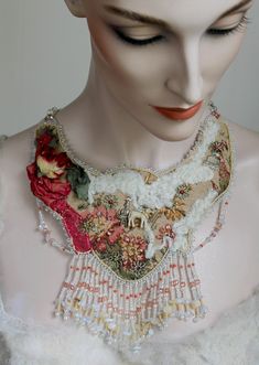 "This one-of-a-kind, fantasy bib necklace is a sweetheart with its \"Mary Had a Little Lamb\" nursery rhyme theme!       Red silk tufted fabric adorns its antique tapestry base. Authentic felted lamb's wool, metal flowers, vintage hat posy, and antique lamb add uniqueness. Additional silver charms and shiny, faceted pink glass beads enrich its splendor. All is stunningly surrounded by myriad white and beige Czech glass seed beads above its rich, glass fringe.     Vintage gold white clear chain makes this beauty fully adjustable to approximately 22\"; all is carefully backed with soft, tan Ultra Suede.       This unique neck piece will definitely prove a conversation starter when worn. It's fun and whimsical." Whimsical Handmade Necklaces For Weddings, Unique White Necklaces For Crafting, Handmade Bohemian Bib Necklaces For Weddings, Unique Red Necklaces For Wedding, Unique Red Necklace For Wedding, Unique Red Wedding Necklaces, Unique Red Wedding Necklace, Vintage Handmade Beaded Necklaces For Wedding, Wearable Art Beaded Necklace As A Gift