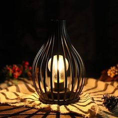 a lit candle sitting on top of a table next to pine cones and other decorations