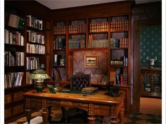 an old fashioned wooden desk in front of a bookcase filled with lots of books