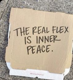 a piece of cardboard taped to the ground with writing on it that says, the real flex is inner peace