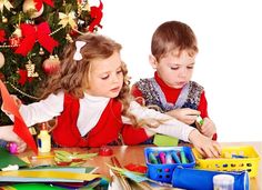 two young children are playing with toys at the table near a christmas tree on a white background