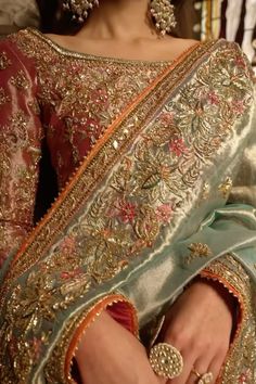 a close up of a woman in a wedding dress with jewelry on her hands and the bride's ring