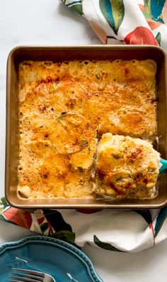 a casserole dish with cheese on top and a fork in the pan next to it