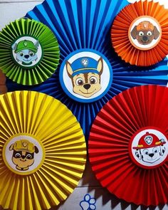 four different colored paper fans with dogs and fire fighters on them, all in the same pattern