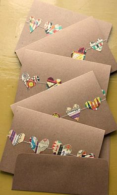 four envelopes with different designs on them sitting on a table next to each other