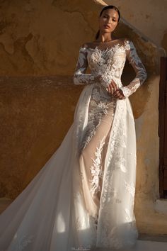 a woman in a wedding dress standing next to a wall