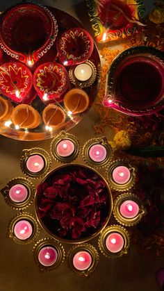 there are many candles and bowls on the table