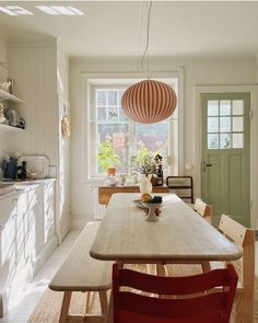 a kitchen with a table, chairs and a lantern hanging from the ceiling above it