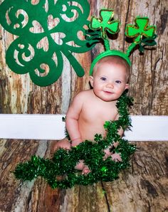 a baby is wearing a green headband and shamrocks for st patrick's day