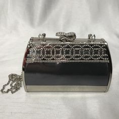 a black and silver purse sitting on top of a white table