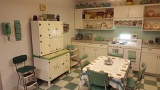 an old fashioned kitchen with green and white decor