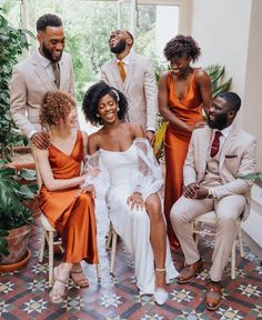 a group of people sitting next to each other in front of a potted plant