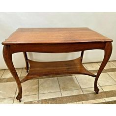 a small wooden table on tiled floor next to wall