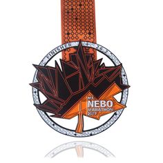 a medal with an orange ribbon around it and a maple leaf on the front side