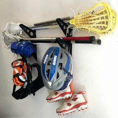 lacrosse stick wall rack Wall Rack Design, Kayak Storage Garage, Skateboard Storage, Door Mounted Spice Rack, Tool Wall Storage, Surfboard Covers, Sports Equipment Storage, Stick Storage, Lacrosse Gear