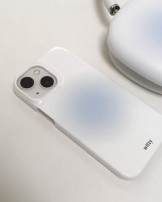 an iphone case sitting on top of a table next to a mouse and headphones