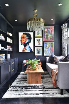 a living room with black walls and pictures on the wall, couches and coffee table