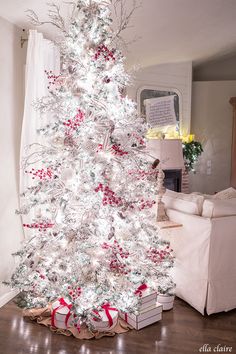 a white christmas tree with red and silver decorations