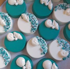 there are many cupcakes decorated with sea shells on the top one is blue and white