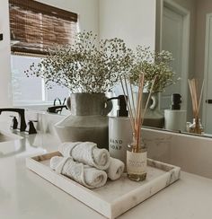 a bathroom counter with towels and candles on it