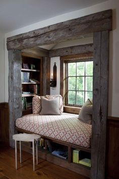 a window seat in the corner of a room with bookshelves on either side