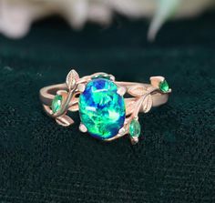 If you would prefer a custom ring, please contact us. PRODUCT DETAILS: Sku  8x6mm Oval Lab Created Peacock Opal Gemstone  Simulated Emerald Accents Plating - 14k Rose gold Vermeil TYPES OF PLATING, VERMEIL & THEIR BENEFITS: 1) Rhodium Plating: Rhodium is a precious metal that is in the family of platinum. There are many upsides of rhodium plated jewelry. First, it increases shine, luster and durability. Additionally, it makes jewelry more resistant to scratches and less prone to tarnish. Rhodium plating is nickel free hence it makes jewelry hypoallergic. 2) Yellow Plating: Yellow plating simply means gold plating but it is slightly different than normal gold plating. Vermeil is hypoallergic and has a thicker layer of gold than normal gold plating, we provide vermeil of 2.5 micron. This add Promise Ring Gift, Fire Opal Ring, Custom Ring, Silver Engagement Rings, Opal Ring, Plated Jewelry, Precious Metal, Blue Rings, Opal Gemstone