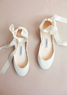 a pair of white shoes with bows on them