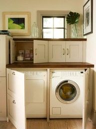 a washer and dryer sitting in a room next to each other on top of a wooden floor