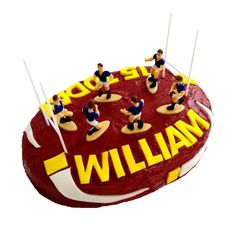 a cake that has people on top of it with the word william spelled in yellow