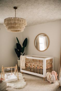 a baby's room with a crib, rugs and a round mirror