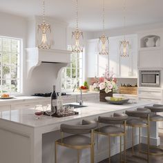 a large kitchen with white cabinets and marble counter tops, an island with stools is shown