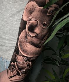 a man's arm with a tattoo of a koala bear holding a cup