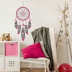 a pink and black dream catcher wall decal on a white wall in a child's room