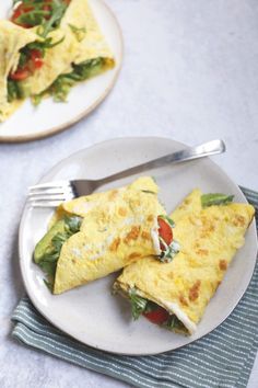 an omelet on a white plate with a fork and napkin next to it