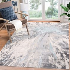 a living room area with a chair, rug and large glass doors that look out onto the outdoors