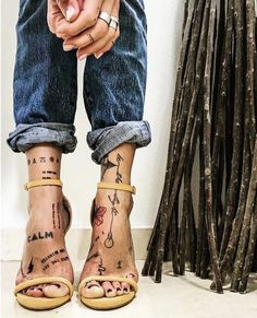 a woman's feet with tattoos on them