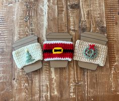 three small crocheted christmas decorations on top of a wooden table