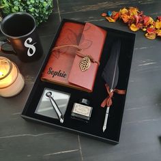 a table with a candle, pen, notebook and some other items on top of it