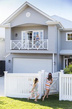 two girls standing in front of a white picket fence with the caption australia hamptons style face garden ideas