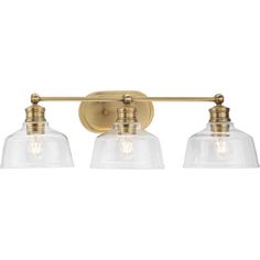 three light bathroom fixture with clear glass shades on the sides and an antique brass finish