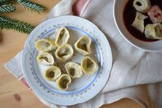 some dumplings are sitting on a plate next to a bowl of soup and a napkin