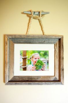 a wooden frame hanging on a wall with a photo in it and the words lake house decor that'll rope