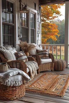 a porch with wicker furniture and fall foliage