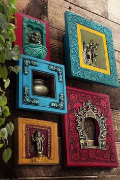 four different colored frames are hanging on the wall with an elephant figurine in it