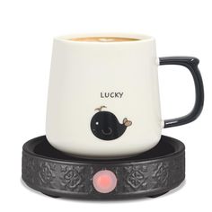 a black and white coffee mug sitting on top of a saucer with a red light in the middle