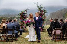 a bride and groom walking down the aisle at their wedding ceremony in front of an outdoor ceremony