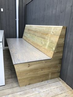 a wooden bench sitting on top of a hard wood floor next to a white table