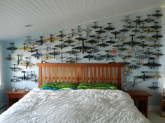 a bed sitting in a bedroom next to a wall with airplanes painted on the walls