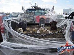 halloween decorations in the back of a truck with net covering it's bed and two skeletons