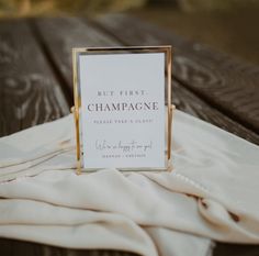 a sign sitting on top of a wooden table next to a white sheet covered ground